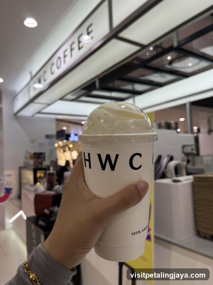 Hand holding a coffee cup with whipped cream