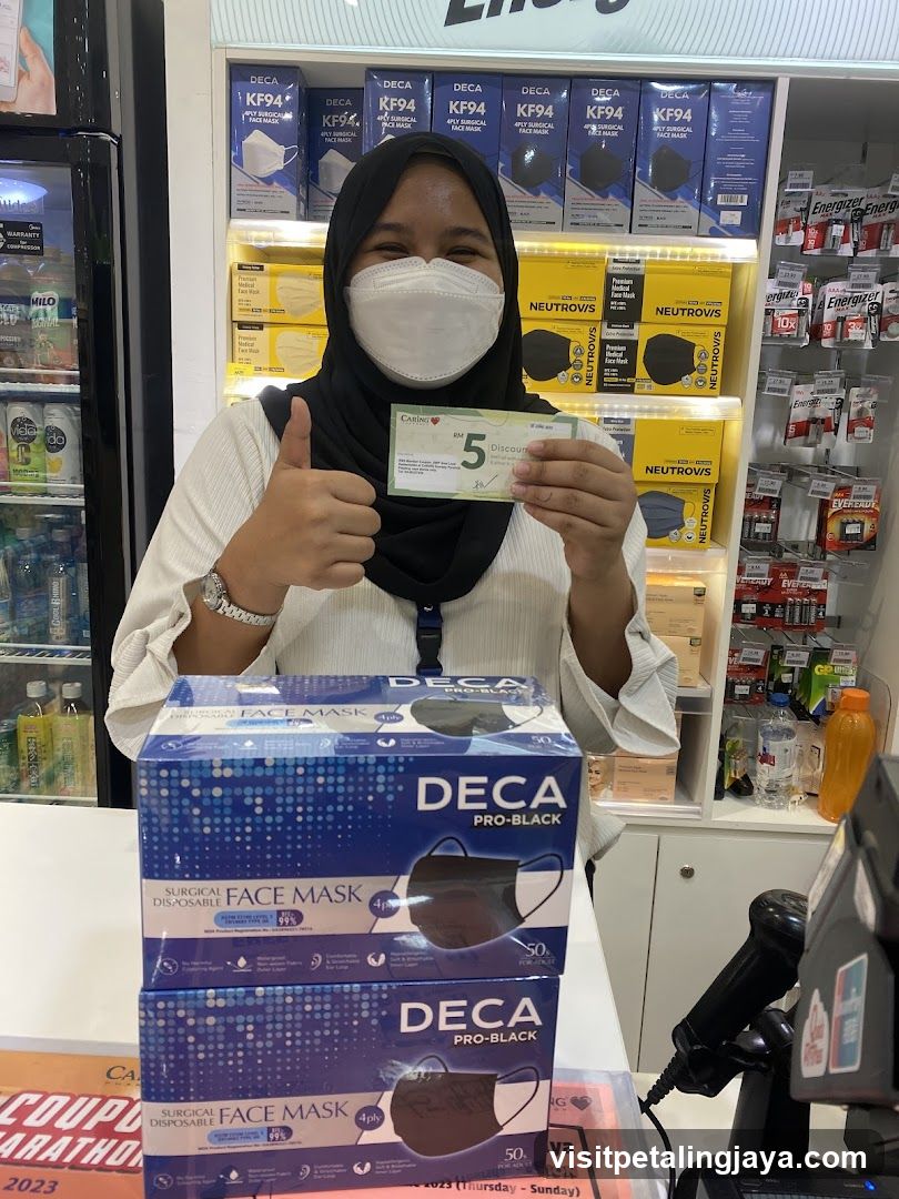 Woman holding a discount coupon and showing boxes of face masks