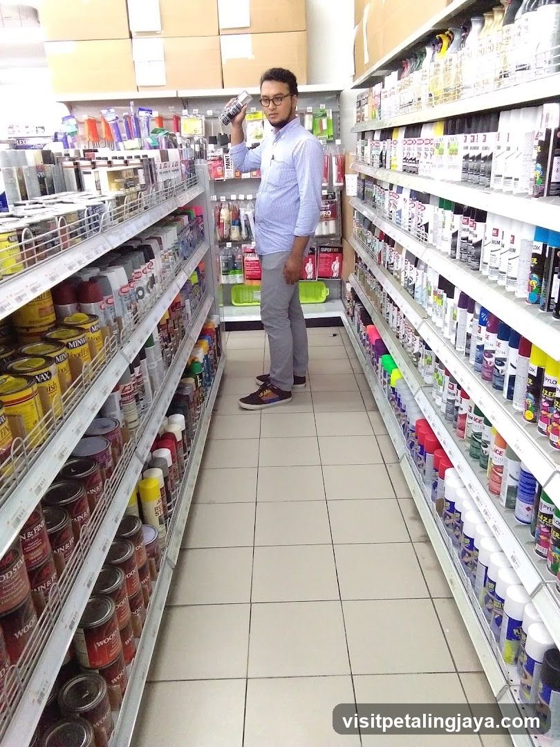 Man holding a spray can in an aisle of a store