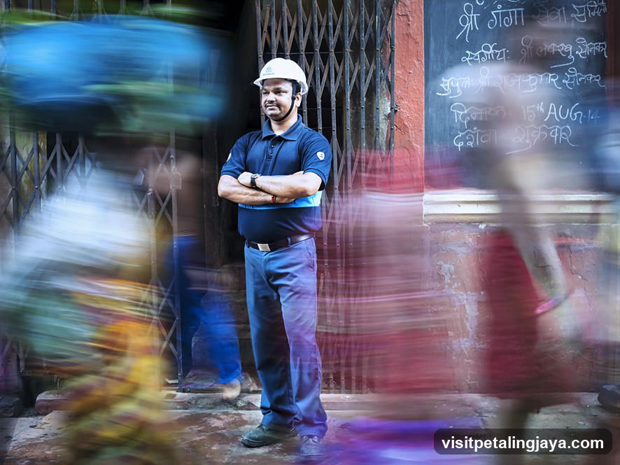 Man in Hard Hat Standing in Front of a Grated Entrance