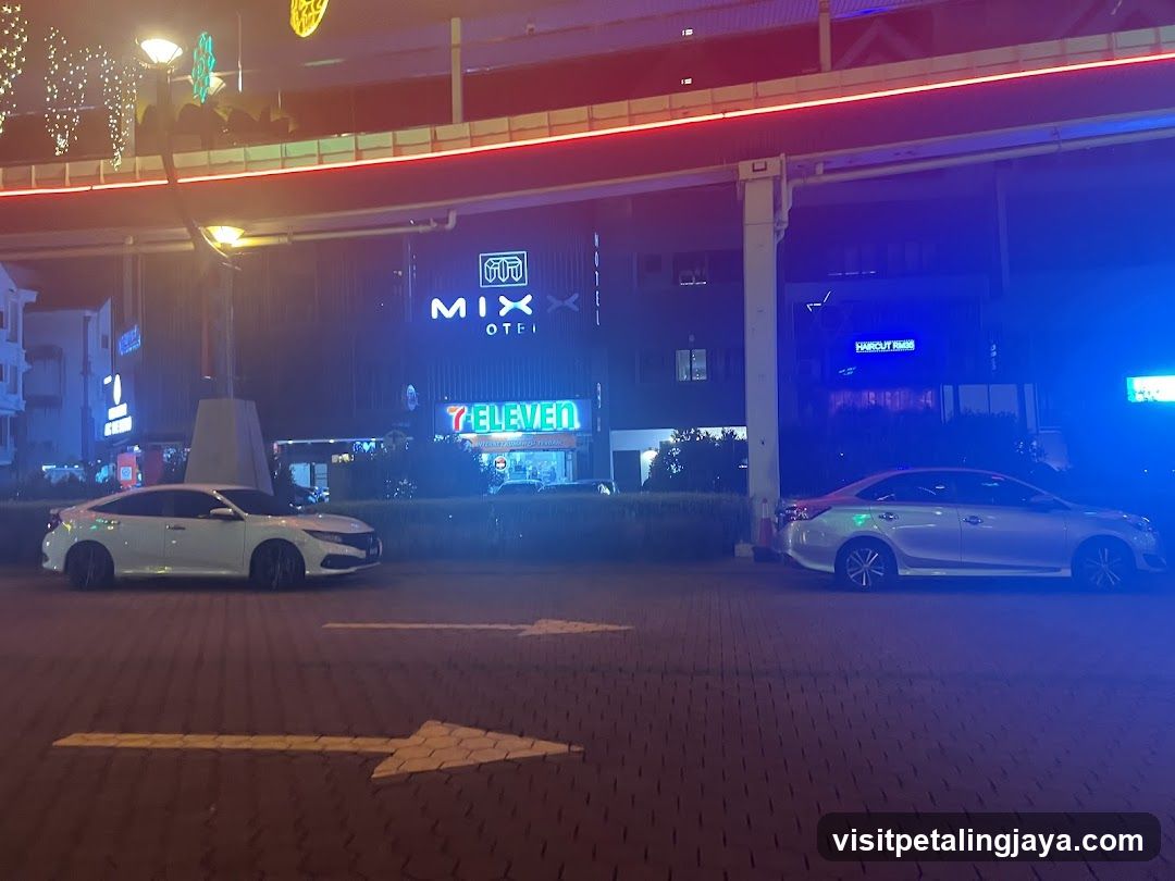 Nighttime street scene with businesses and cars