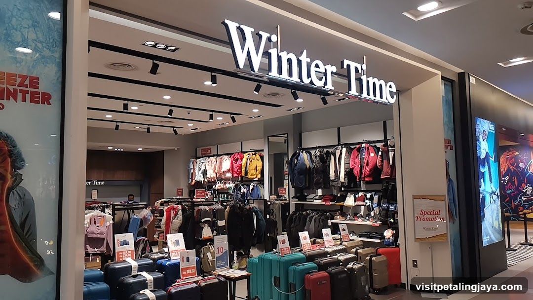 The storefront of a clothing store called Winter Time. The store displays a variety of winter clothing such as jackets and sweaters, as well as luggage. There are also promotional signs visible.