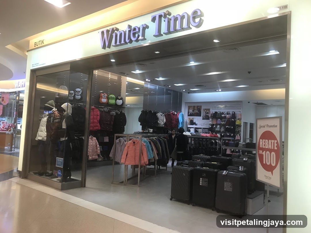 The exterior of a clothing store called "Winter Time" is visible, featuring a display window with mannequins dressed in winter clothing. Inside, racks of jackets and other apparel are displayed, along with luggage. A promotional sign for a rebate is also present.
