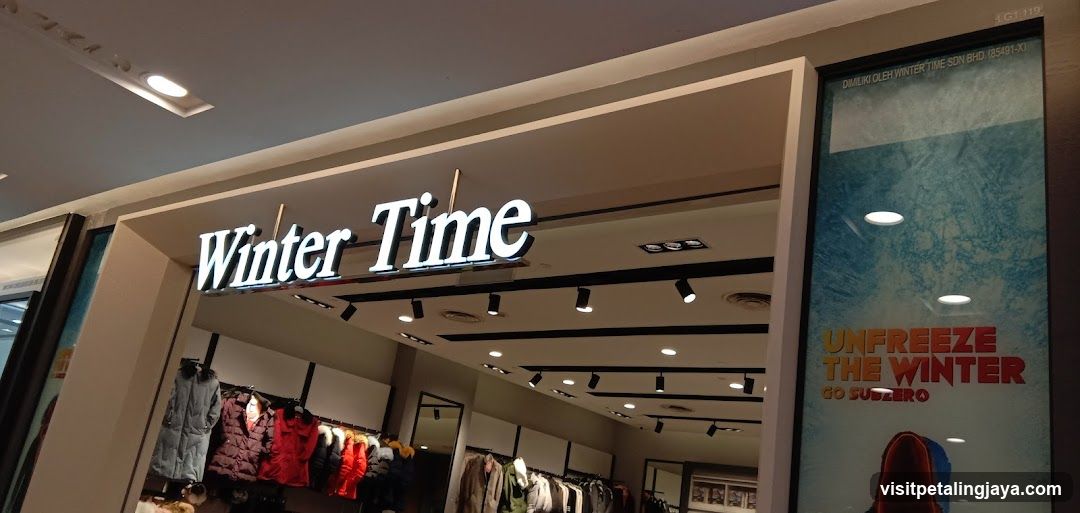The image shows the exterior of a store named "Winter Time". The store's name is displayed in large, illuminated white letters above the entrance. Inside, racks of winter clothing such as coats and jackets are visible. A large poster on the right side of the entrance reads "UNFREEZE THE WINTER GO SUBZERO".