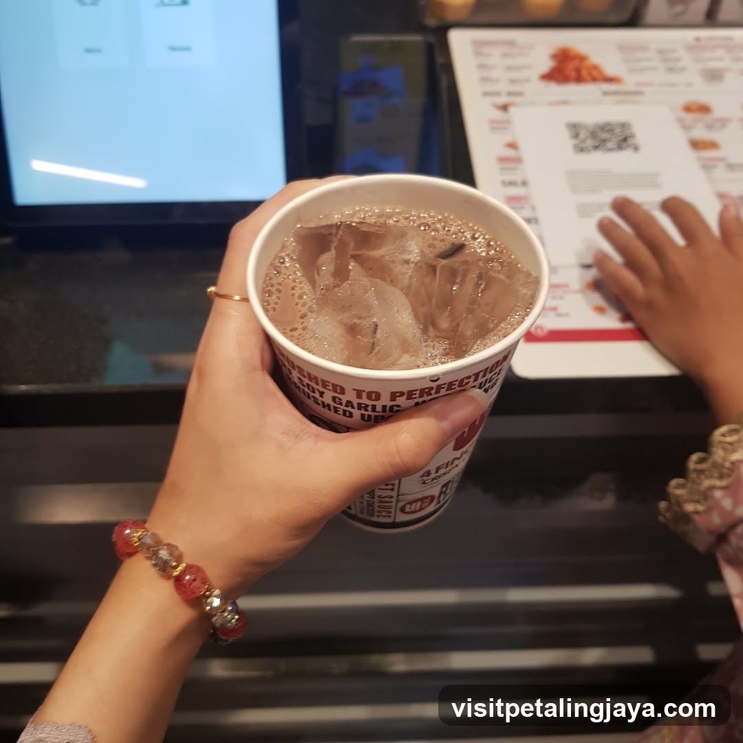 Person holding a drink in front of a menu