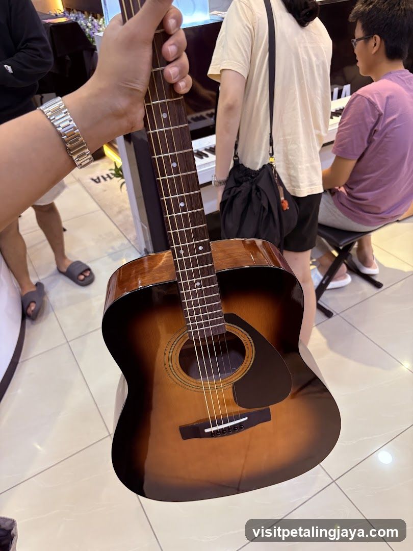 Person holding an acoustic guitar in a music store