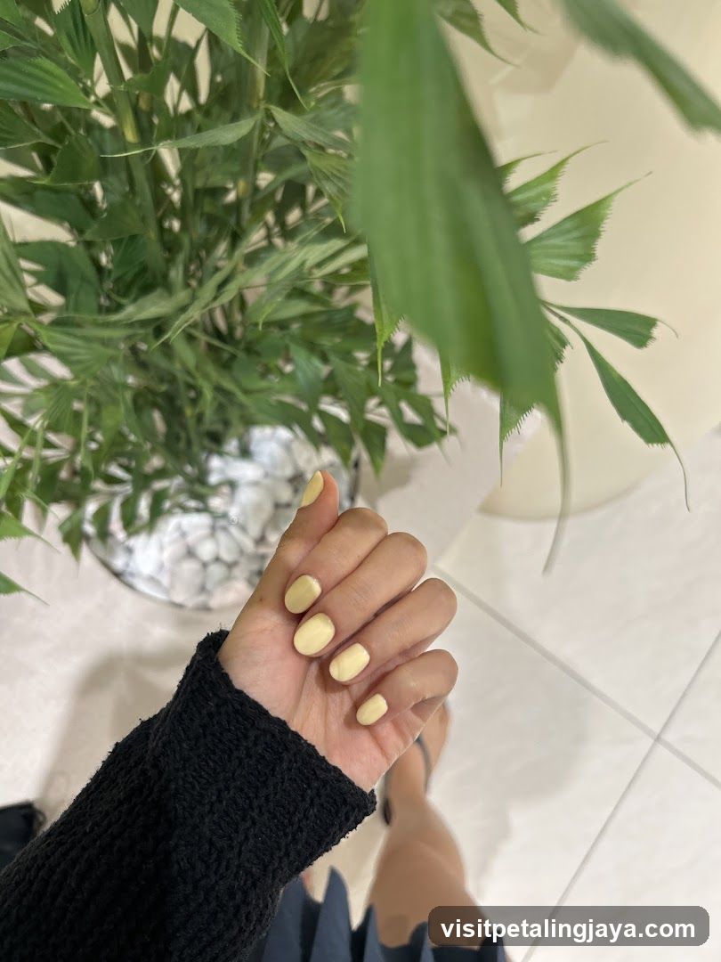 Woman's Hand with Yellow Nail Polish