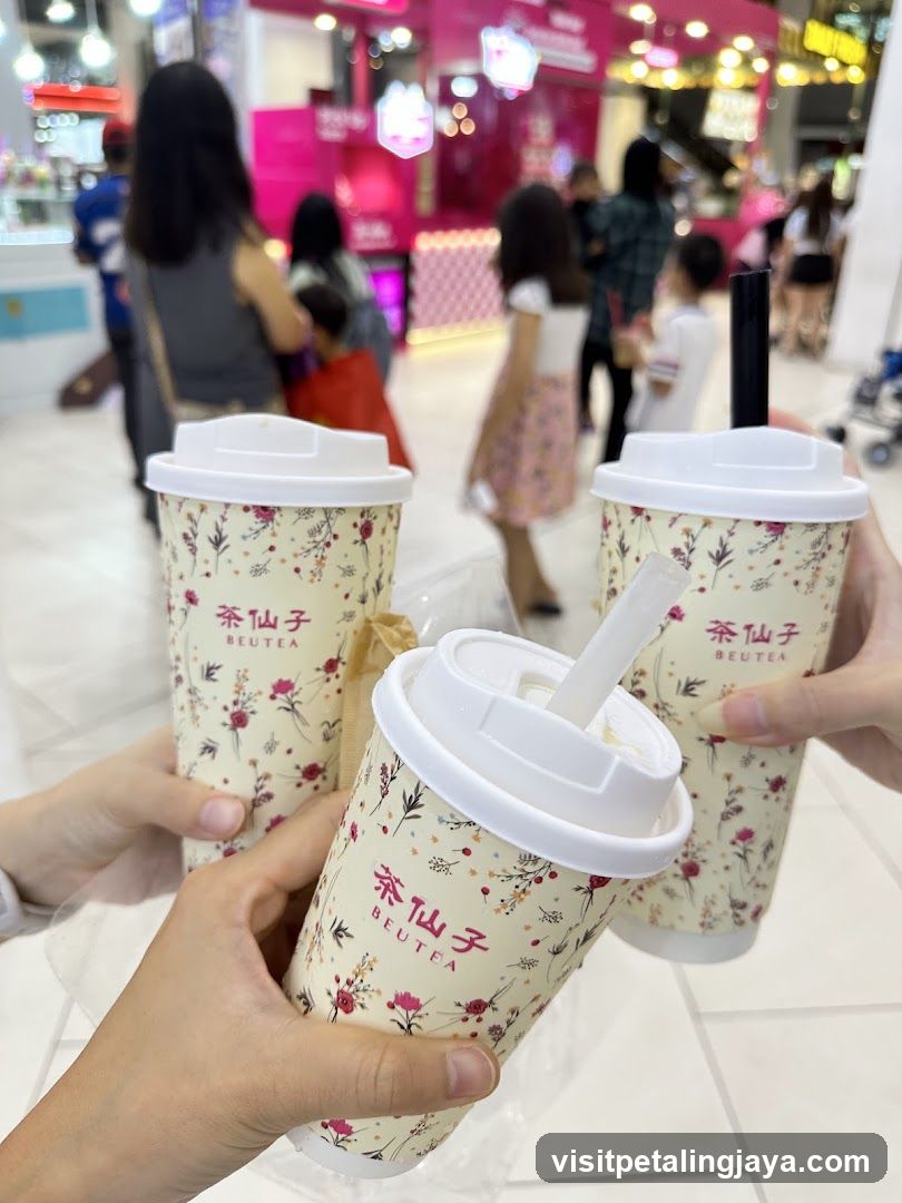 Three floral patterned cups with lids and straws
