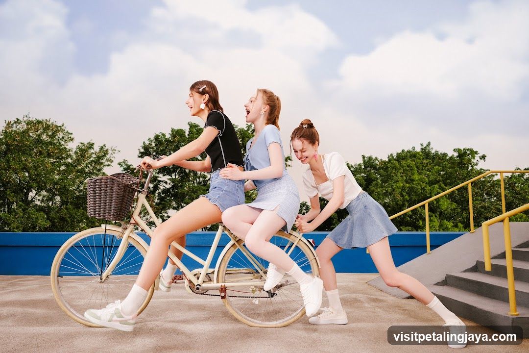 Three young women riding a bicycle