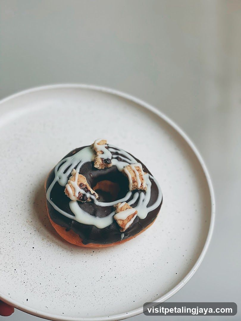 Chocolate Glazed Donut with White Drizzle and Toppings