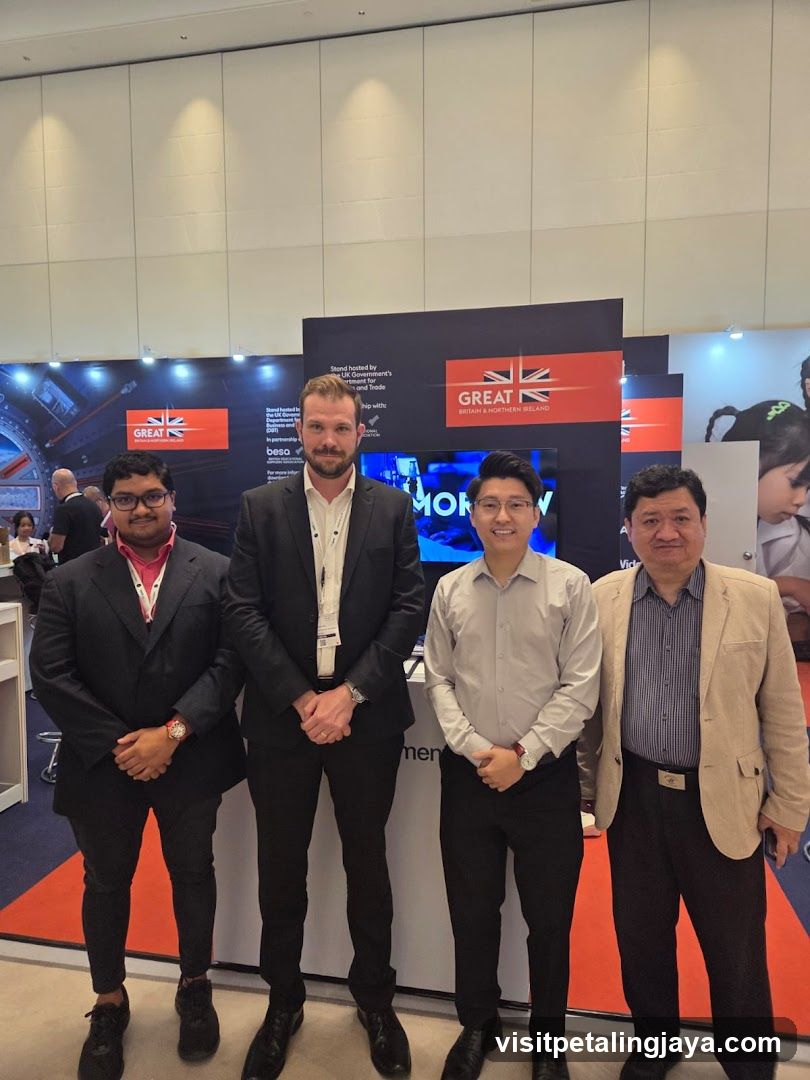 Four men posing at a trade show booth