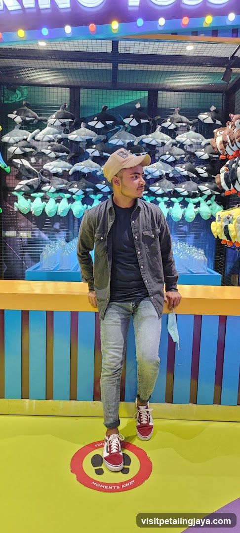 Man Posing in Front of Plush Toy Display