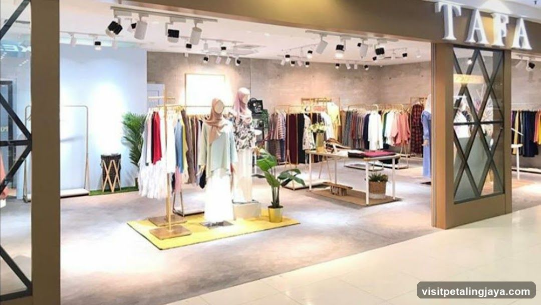 The exterior of a clothing store with the name "TAFA" visible above the entrance. Inside, racks of clothing are displayed, along with mannequins dressed in outfits. The store appears modern and well-lit.