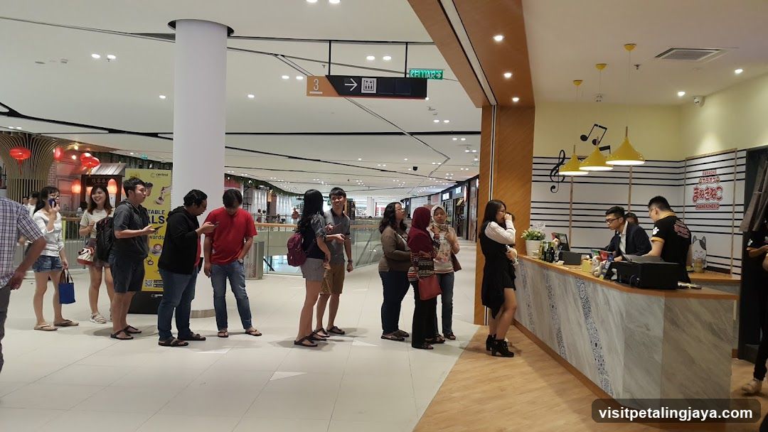 People queuing at a food stall in a mall