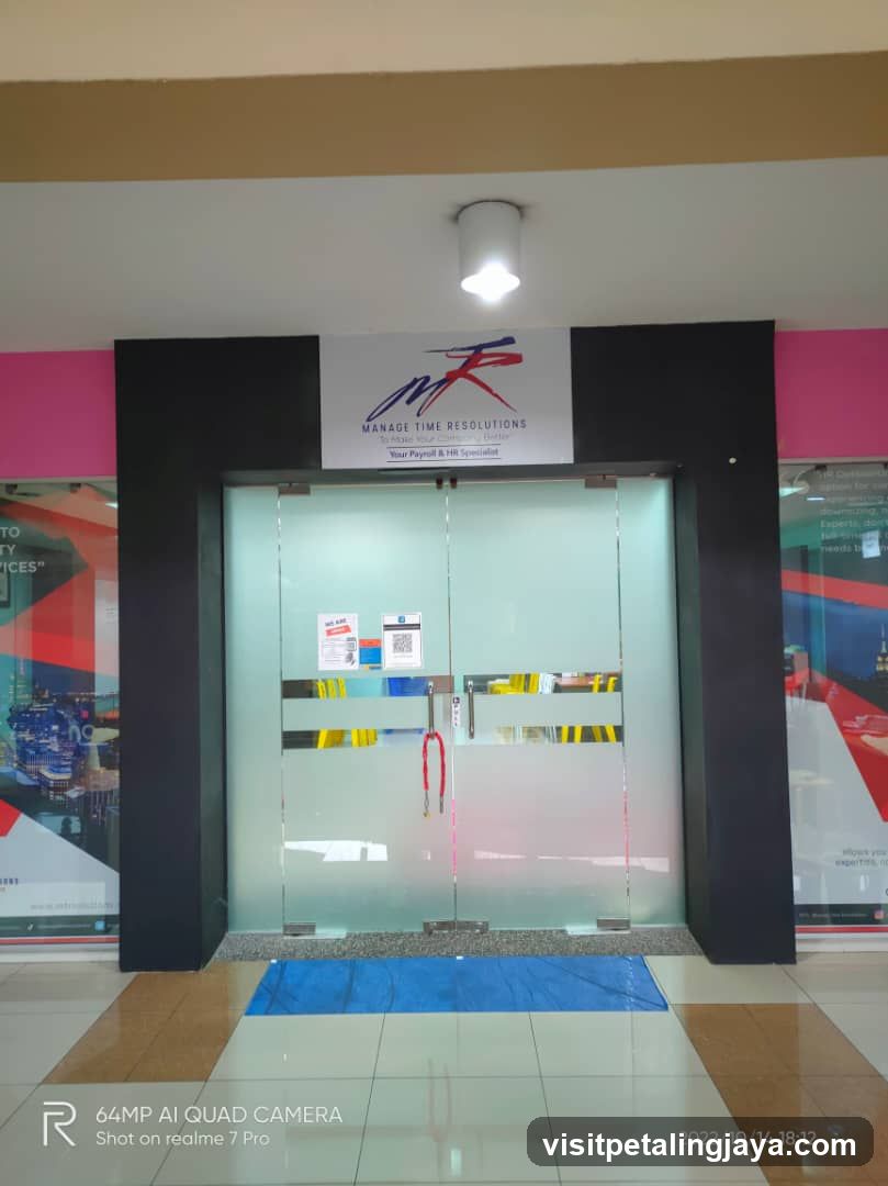 The storefront of Manage Time Resolutions, a payroll and HR specialist. The entrance features frosted glass doors with a sign above displaying the company logo and name.
