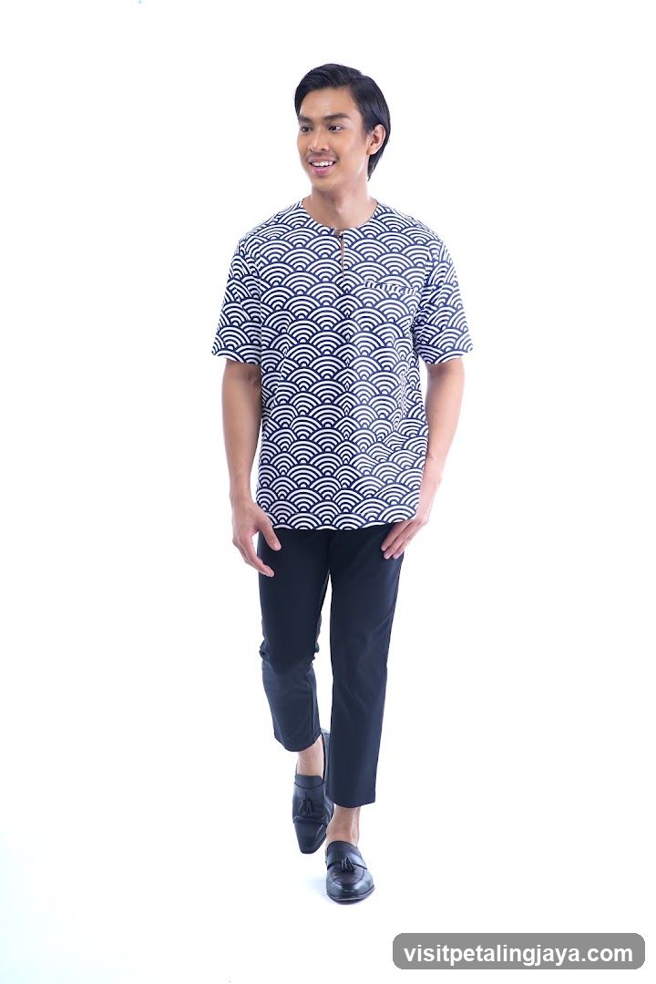 Man in patterned shirt and black pants