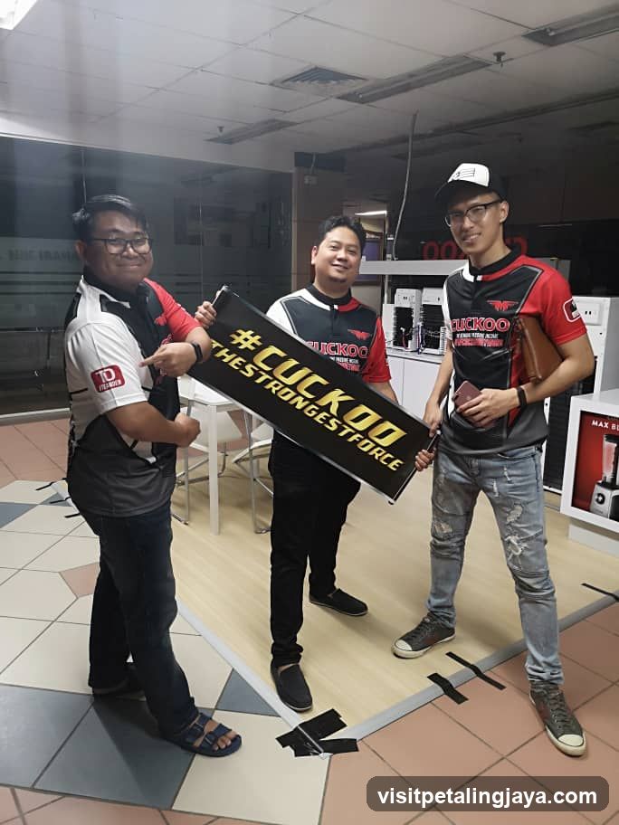Three men holding a banner