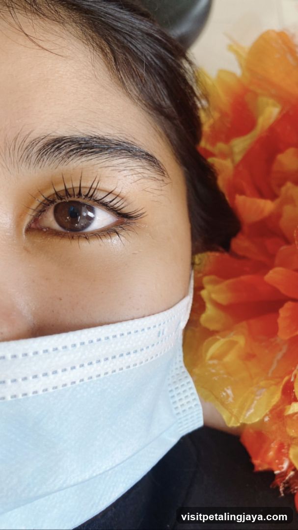 Close-up of a person's eye with a face mask and floral decoration