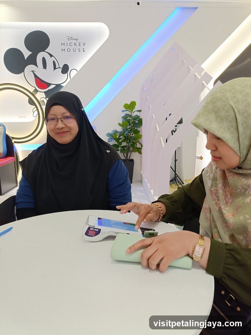Two women at a table with a payment terminal
