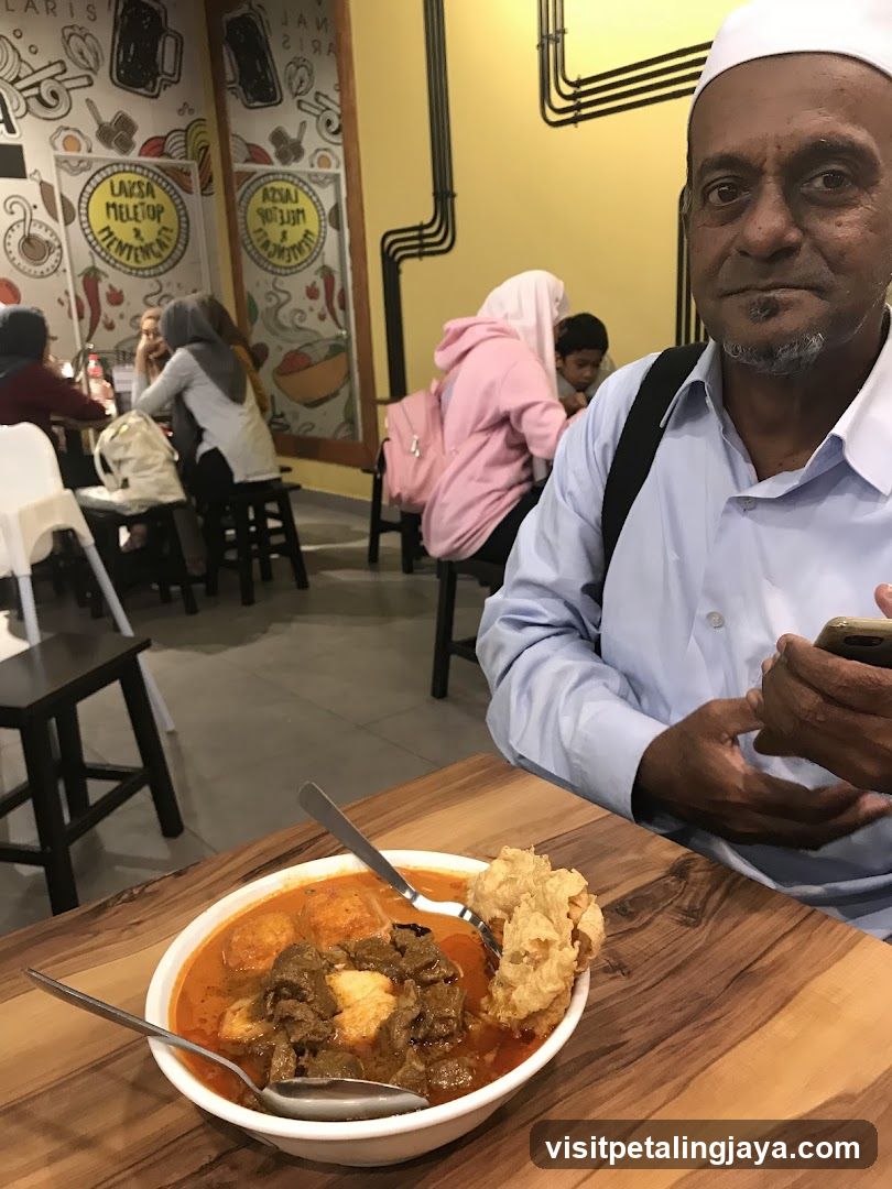 Man with a bowl of curry noodles