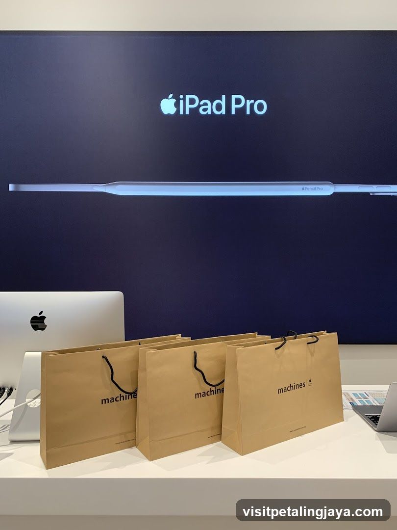 Apple iPad Pro and Pencil Pro display with branded shopping bags