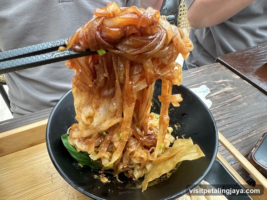 Noodles being lifted with chopsticks