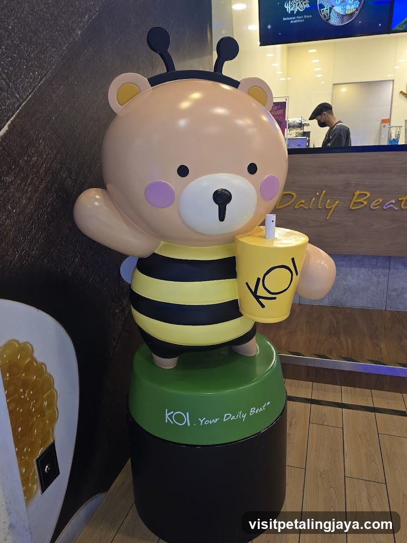 Bear-bee mascot holding a KOI drink