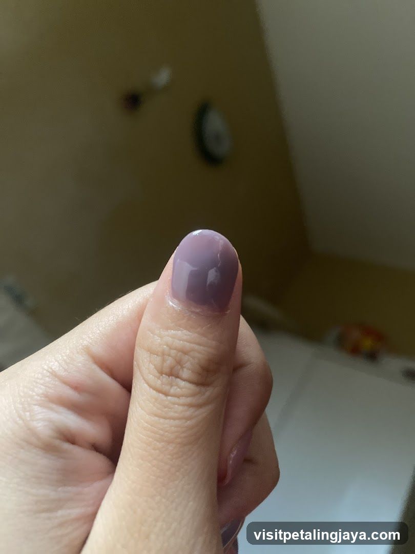 Thumb with Purple Nail Polish