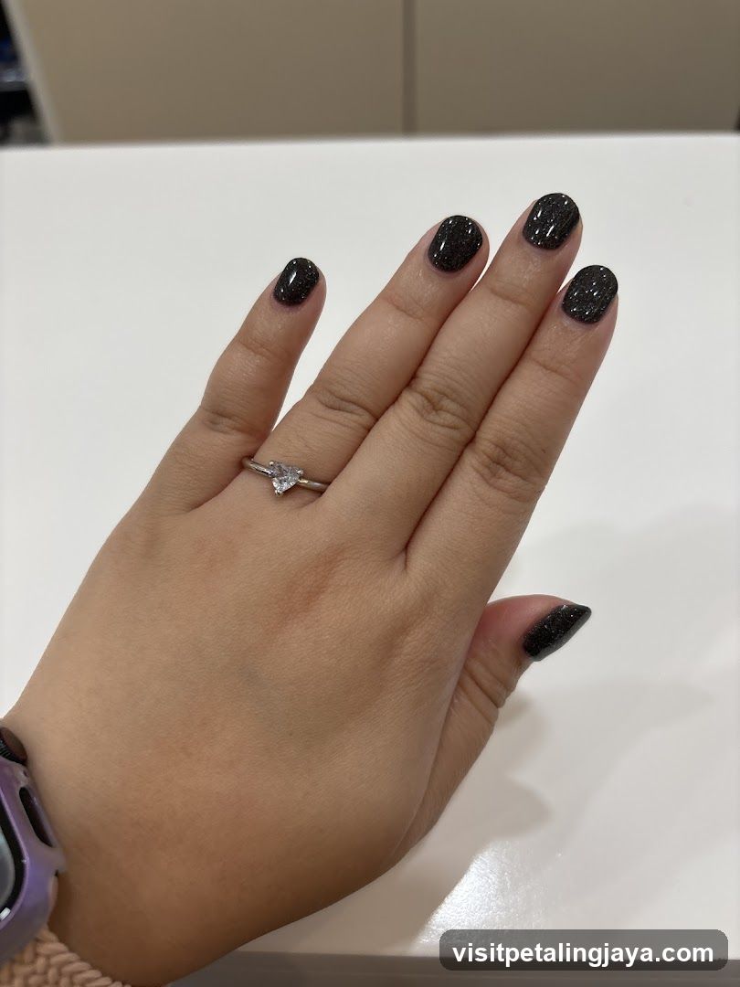 Hand with Ring and Dark Glitter Nails