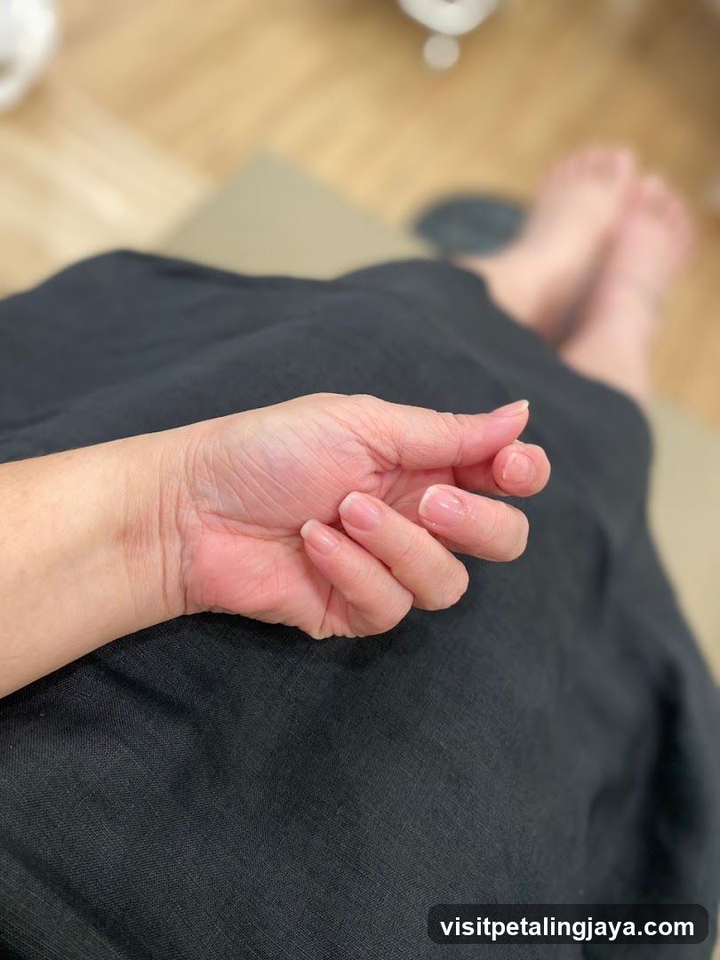 Close-up of a person's hand and arm resting on black fabric.