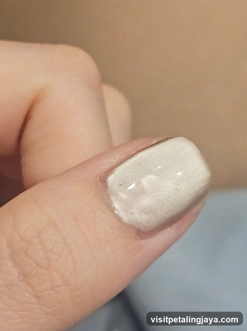 Close-up of a fingernail with light-colored polish