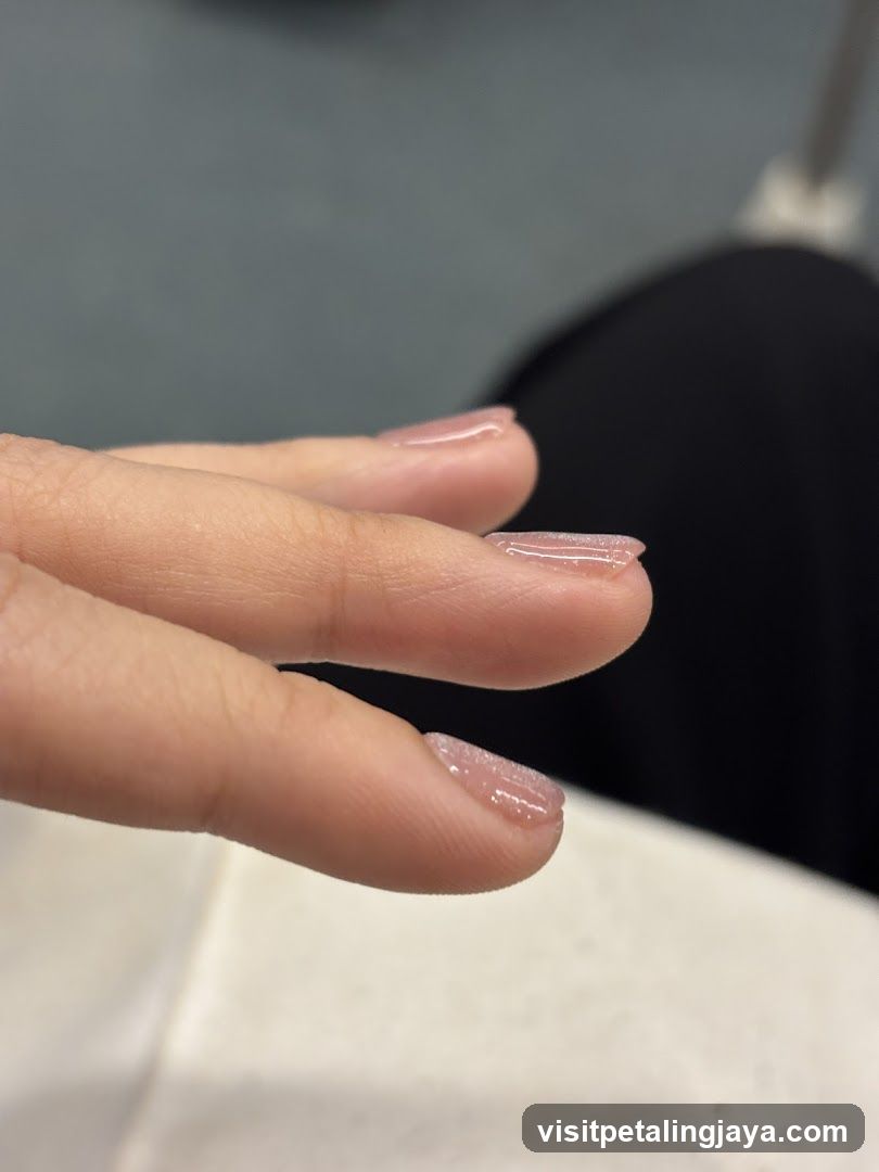 Close-up of fingers with light pink nail polish