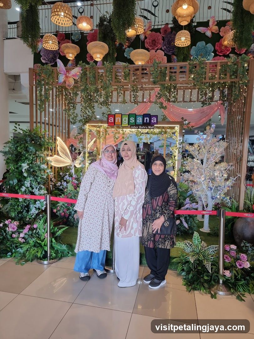 Three women posing in front of a decorative display