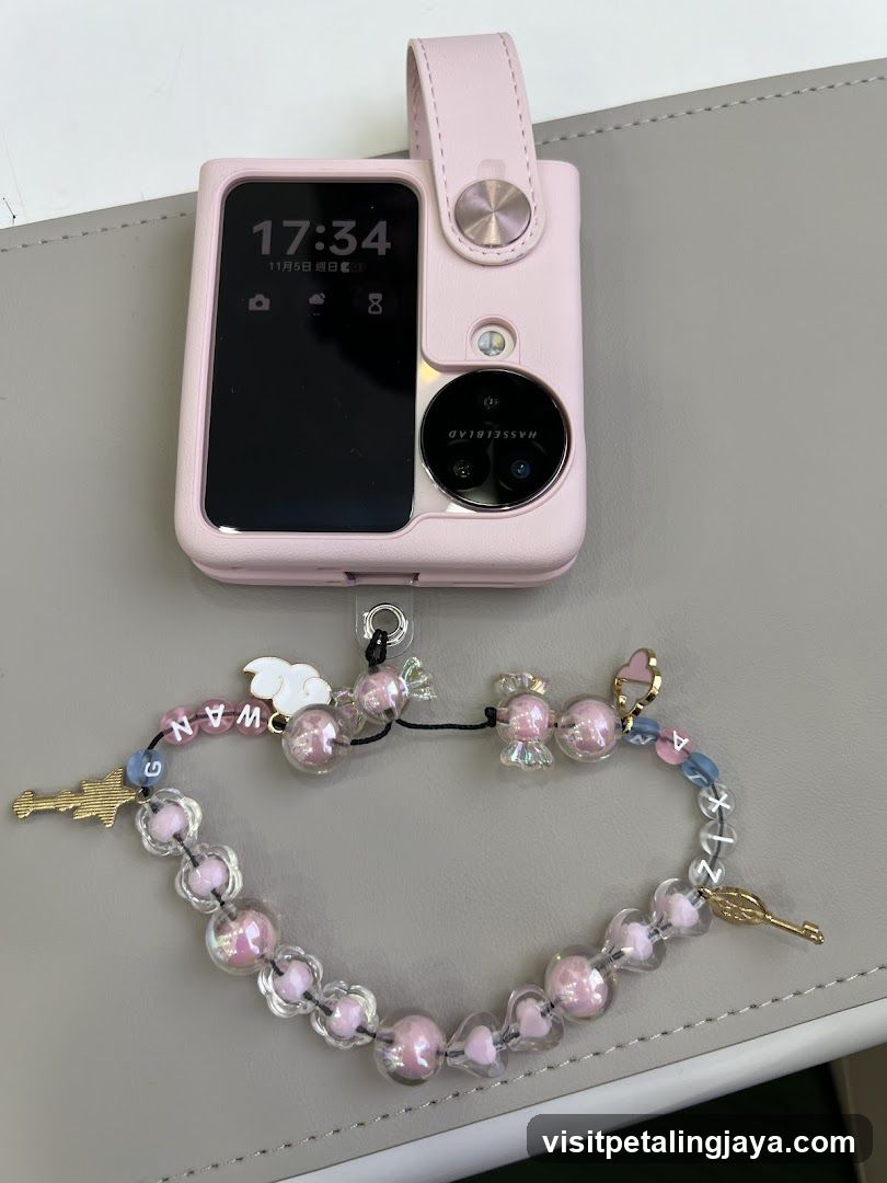 Pink smartphone with decorative strap
