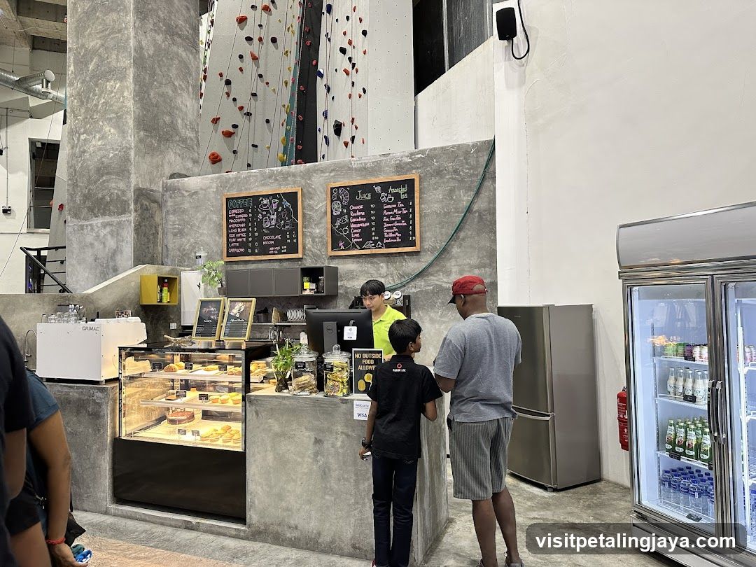 Indoor café area with climbing wall background