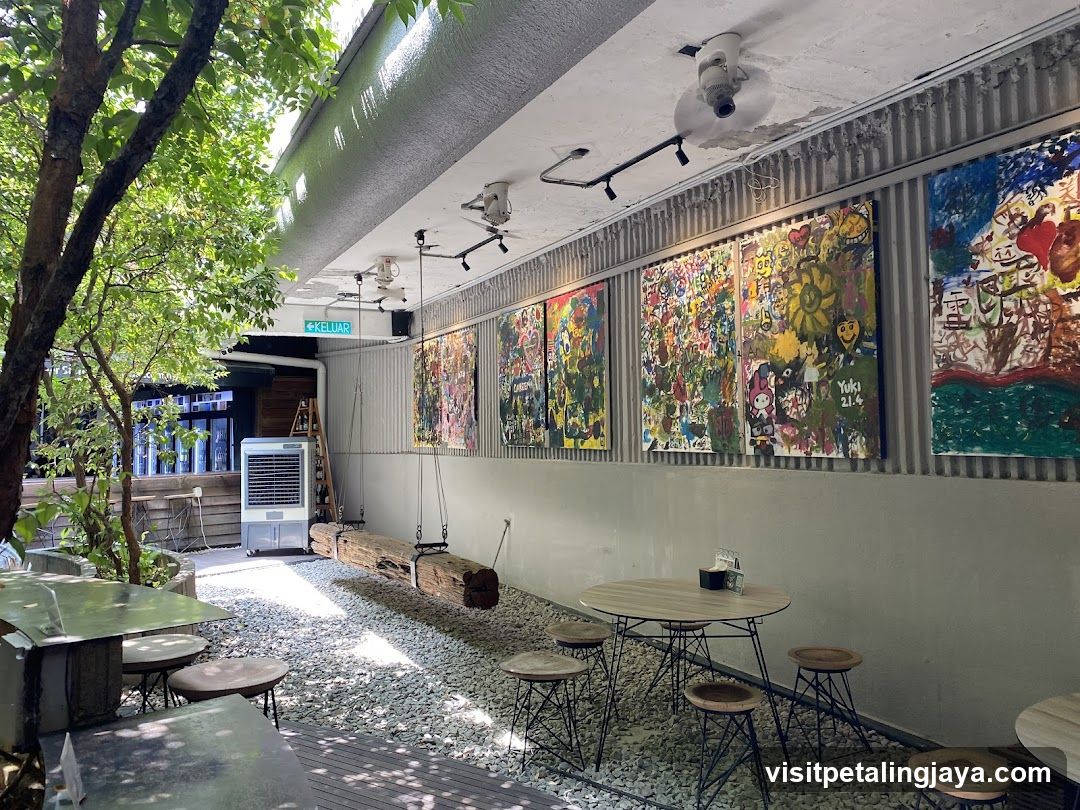 Outdoor seating area with art and greenery