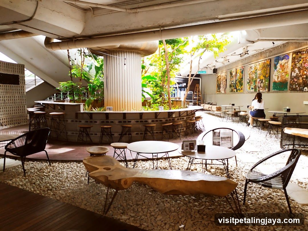 Modern cafe interior with lush greenery and art