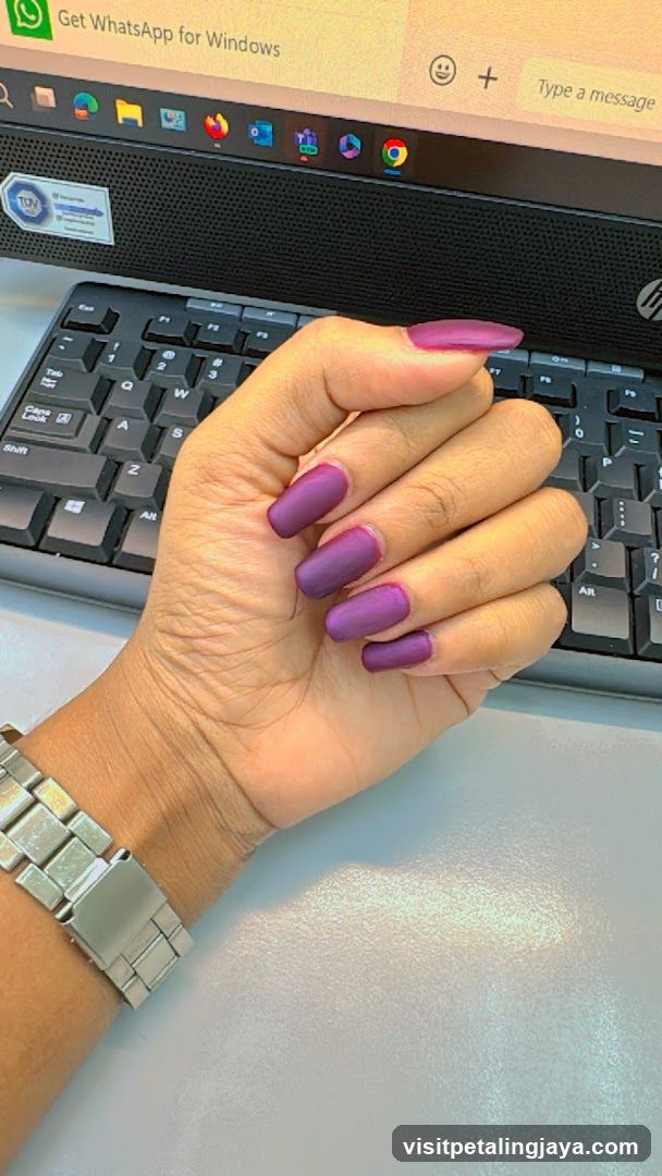 Hand with purple nails on keyboard