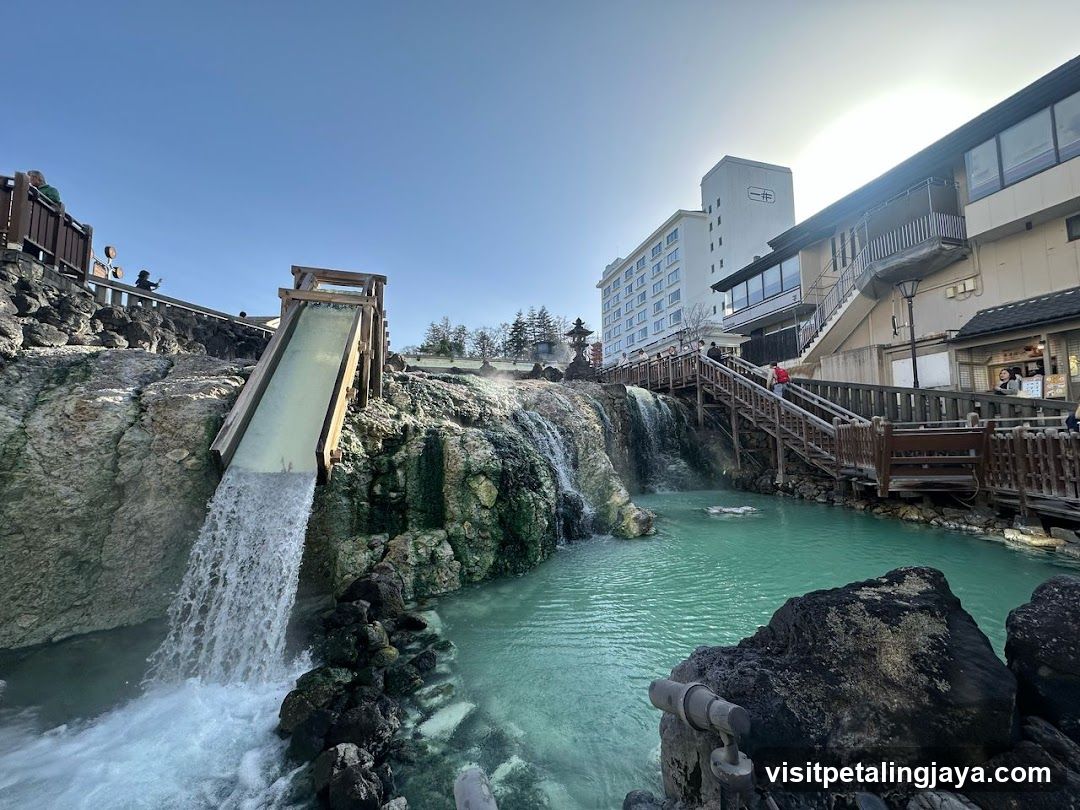 Onsen Hot Spring Scene with Waterfall and Buildings