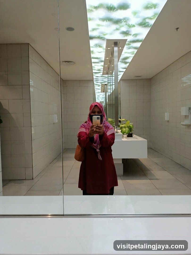 Woman taking a mirror selfie in a modern restroom