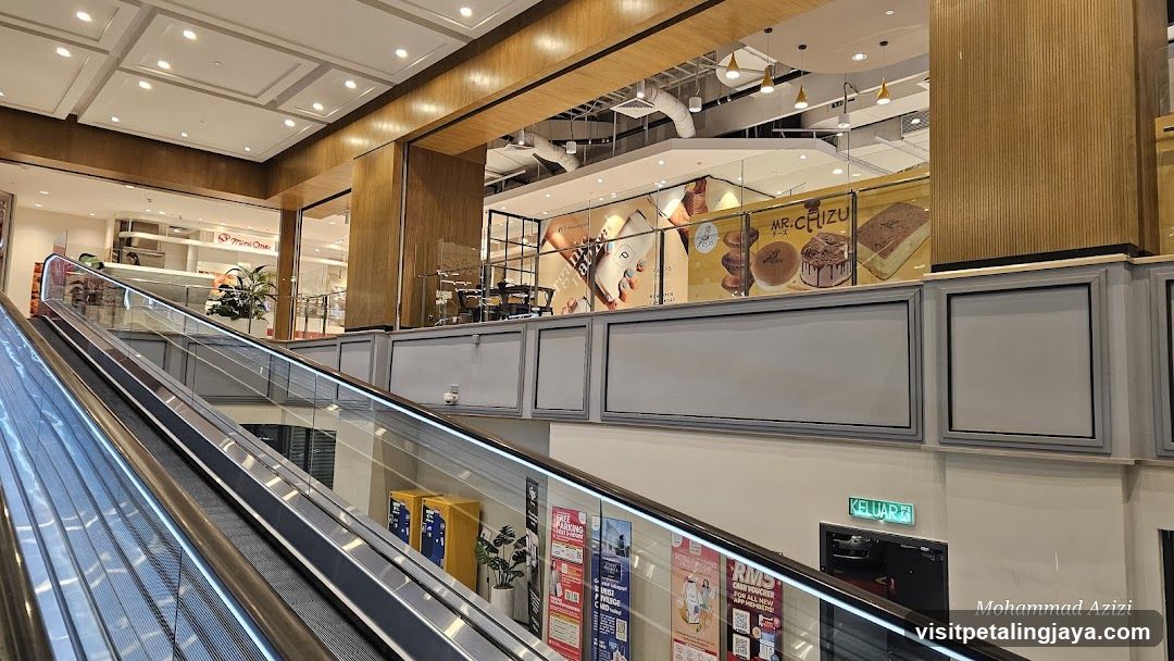 Shopping Mall Interior with Escalator and Storefronts