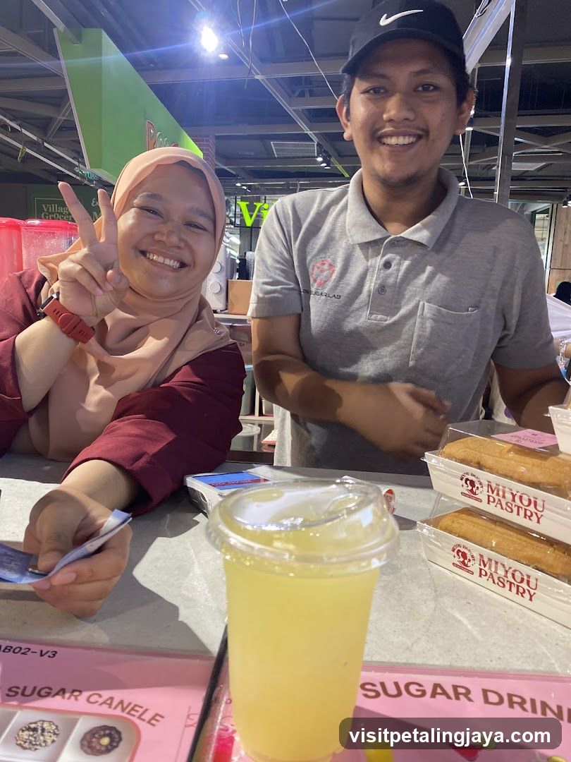 Two people at a counter with pastries and a drink