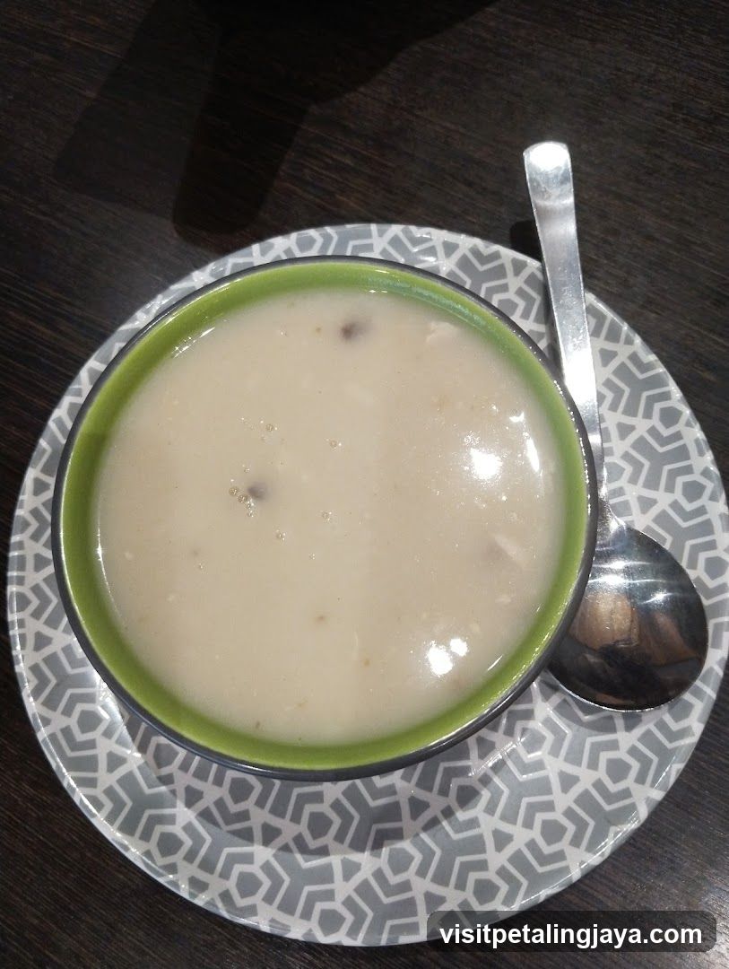 Soup in bowl with spoon on patterned plate