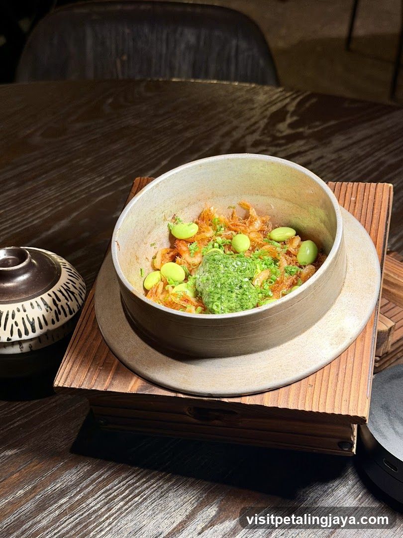 Bowl of food with green garnish and edamame beans
