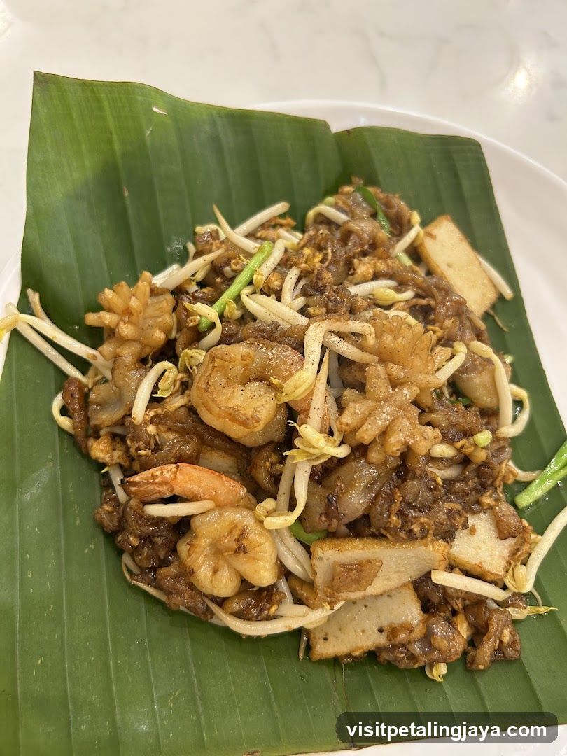 Stir-fried noodles with shrimp and tofu on banana leaf
