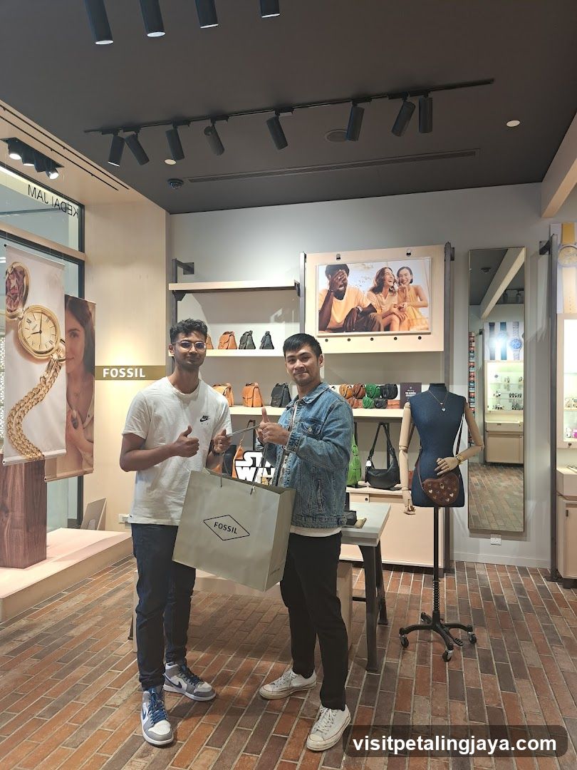 Two men posing with a Fossil shopping bag