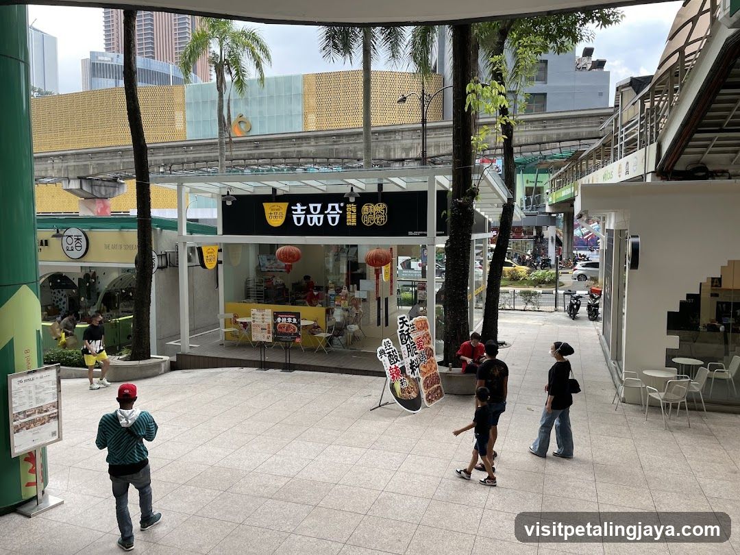 Outdoor Mall Scene with Food Stall and Pedestrians