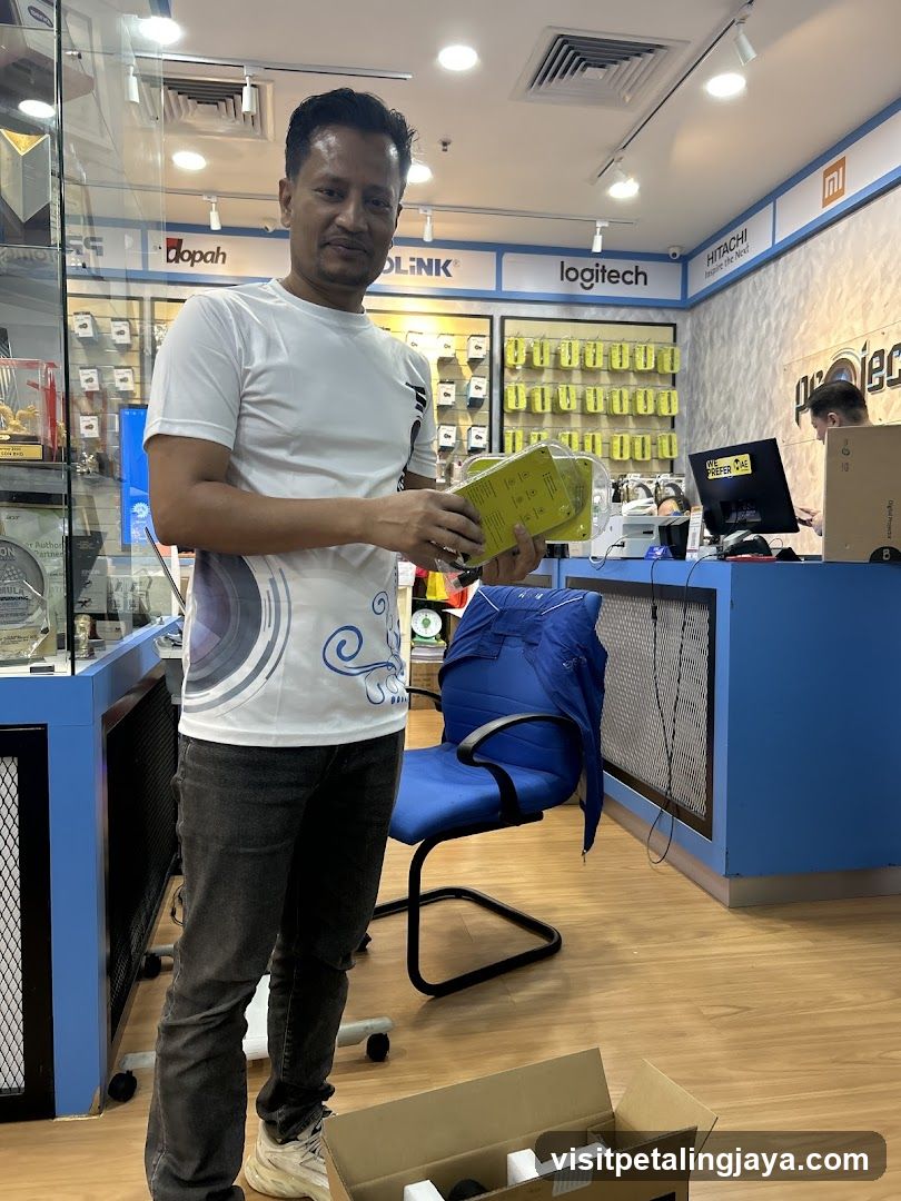 Man holding yellow box in electronics store