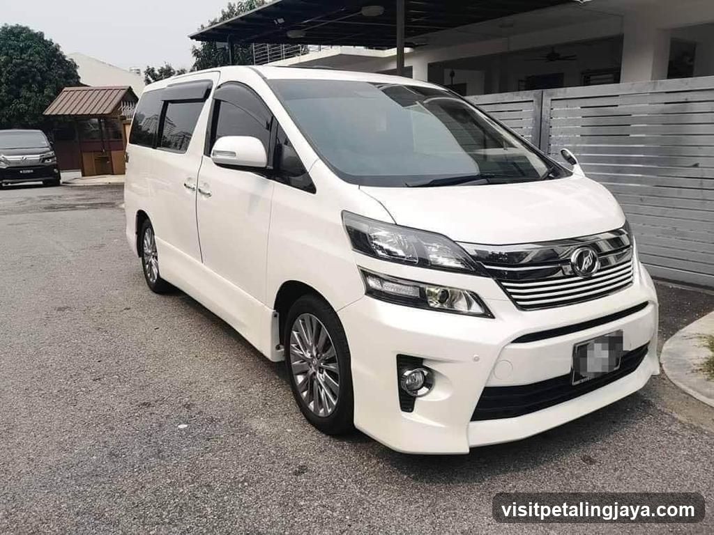 White Toyota Alphard parked outside a house
