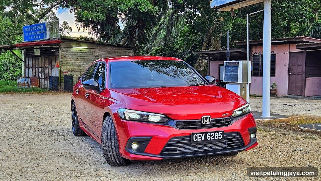 Red Honda Civic parked near a shop